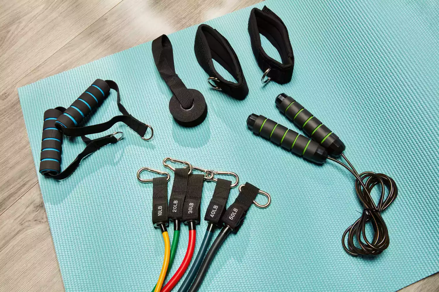 Components of the Chareada Resistance Bands Set on a blue yoga mat