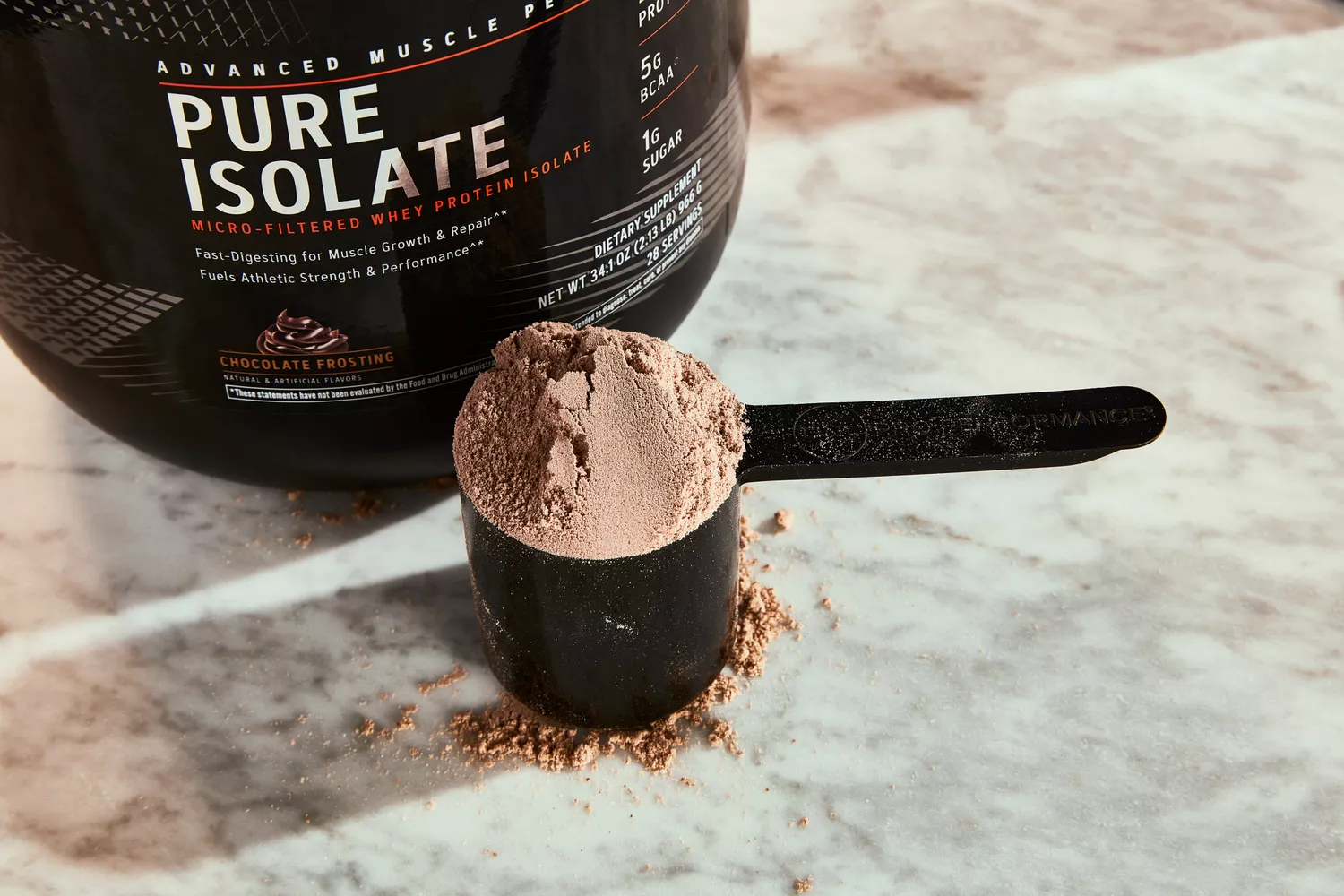 GNC AMP Pure Isolate Whey Protein powder in a scoop