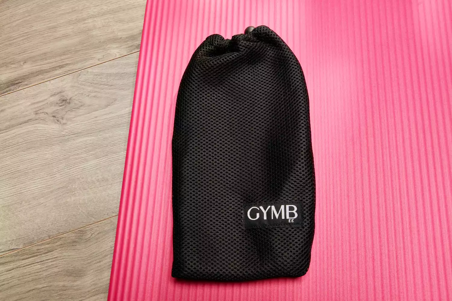 The carrying bag for the GYMB Non-Slip Resistance Bands on a pink yoga mat