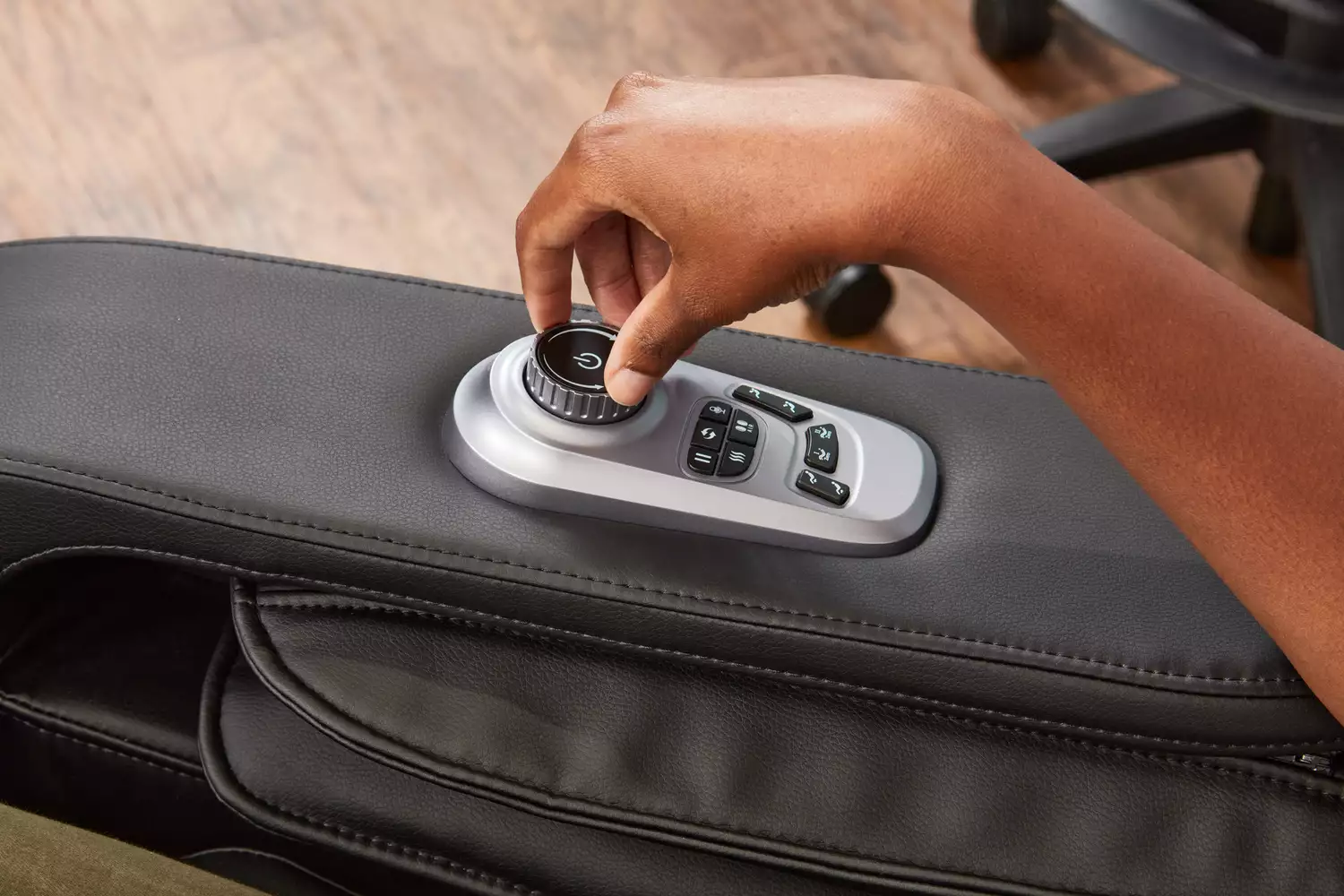 Close-up of a hand adjusting the control knob on an iRest Zero Gravity Massage Chair