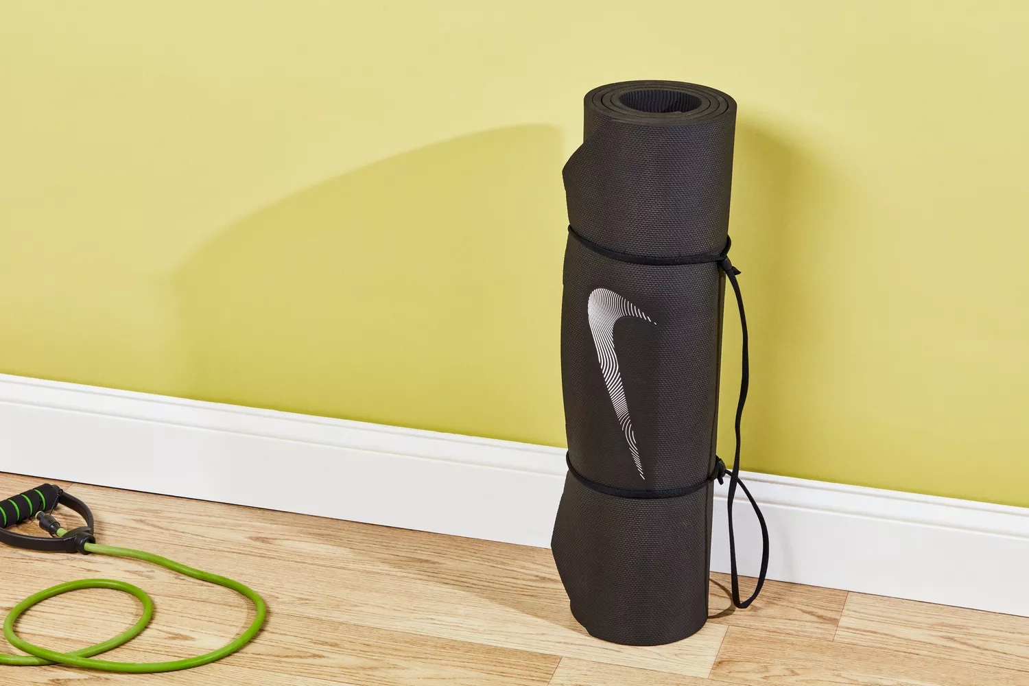 A rolled Nike Training Mat 2.0 surrounded by gym accessories