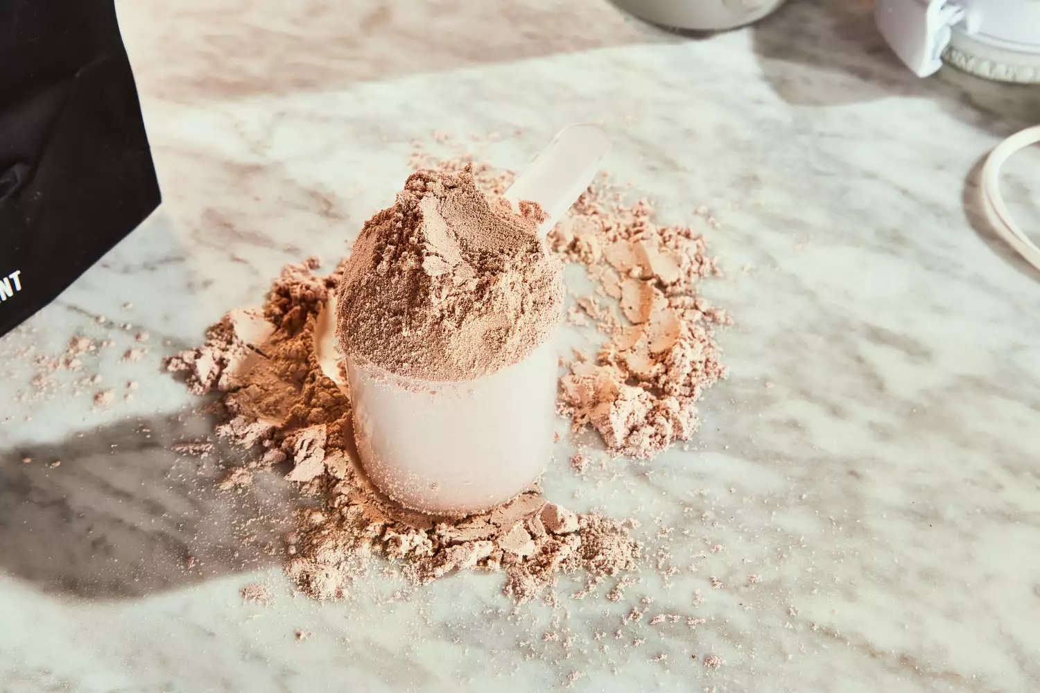 Scoop of Xwerks Grow 100% New Zealand Grass-Fed Whey Protein Isolate on a marble counter