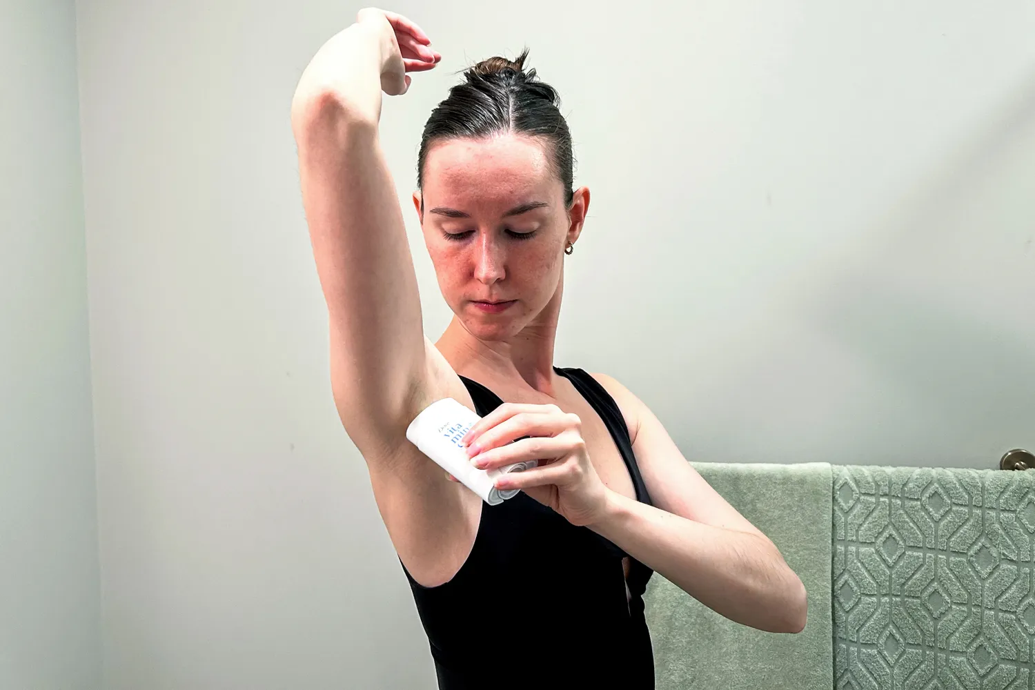 A person applies Dove VitaminCare+ Deodorant Stick to their underarm