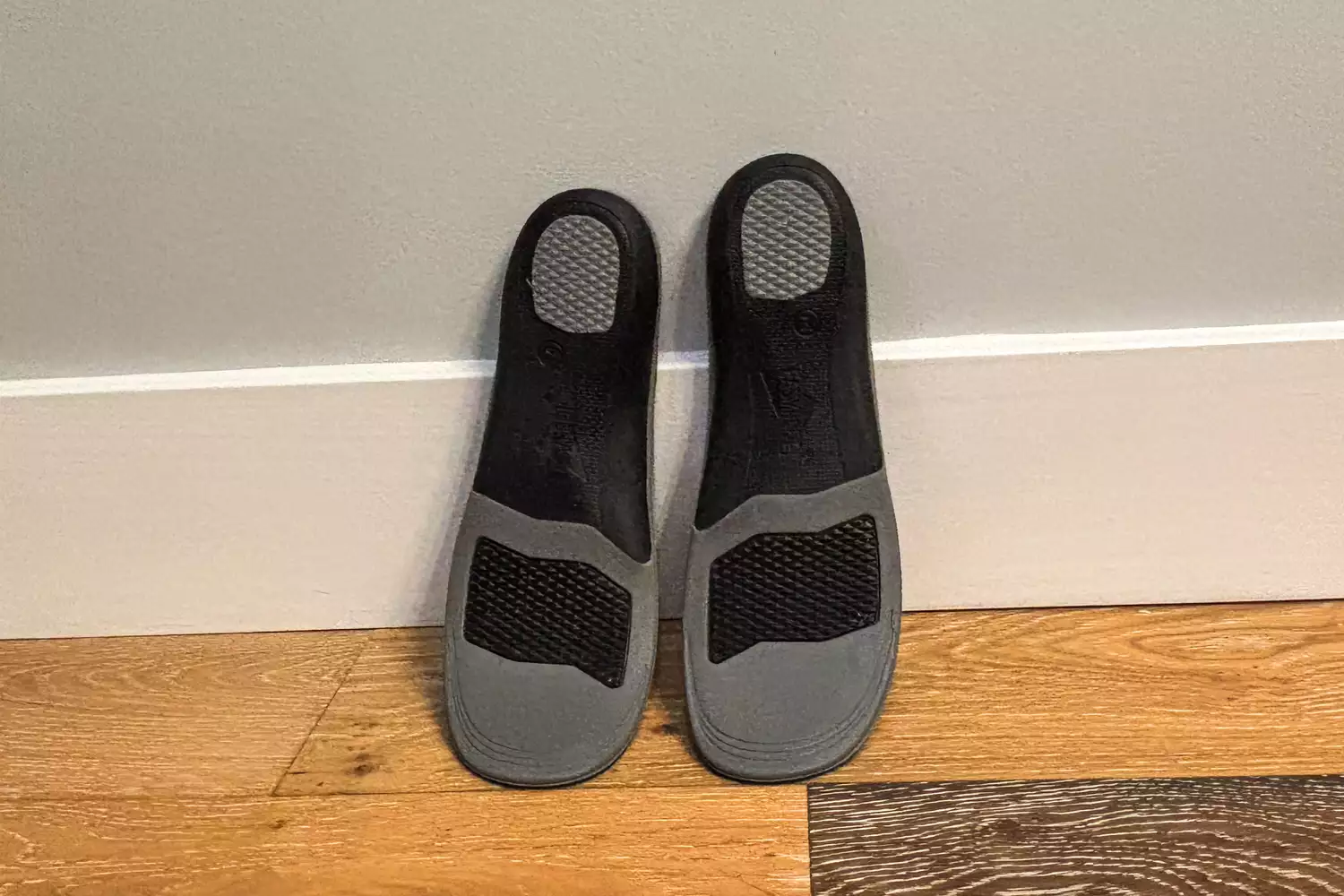 The EasyFeet Black Onyx Pain Relief Premium Orthotics lean against a wall