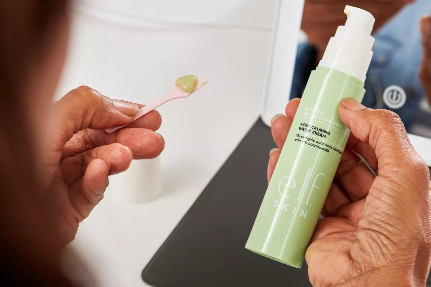Hand holding a bottle of e.l.f. Blemish Breakthrough Calming Water Cream