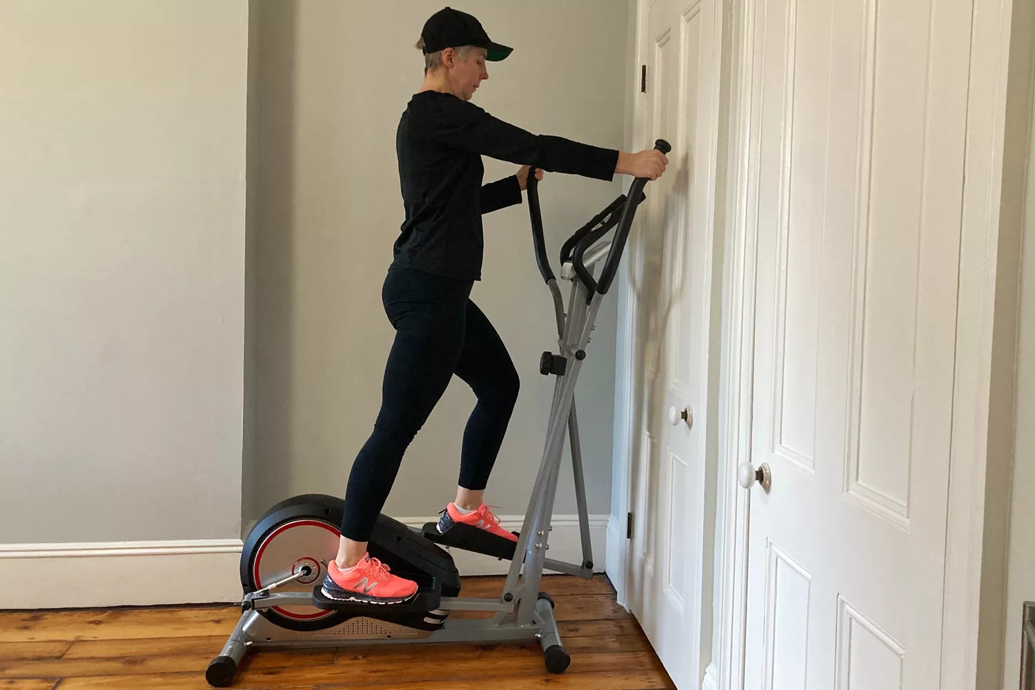 A person on the EFITMENT Magnetic Elliptical Machine in a corner