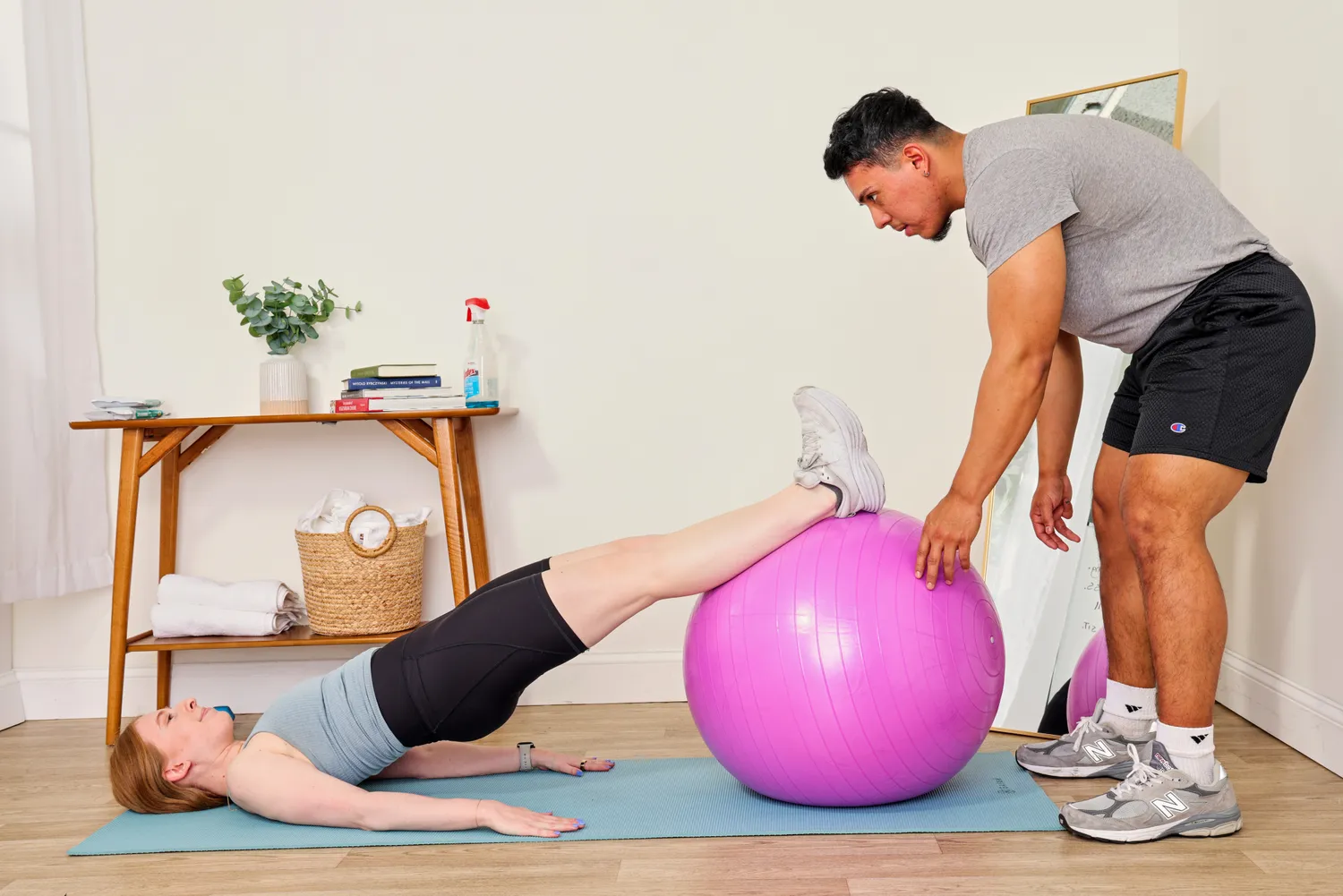 A person helps a person work out using the Black Mountain Professional Grade Stability Ball