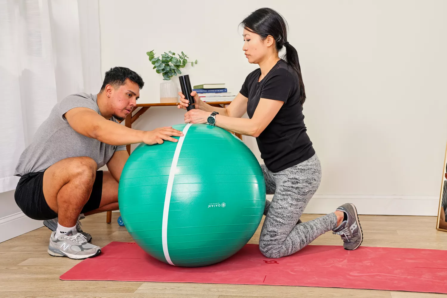 A person measures the Gaiam Total Body Balance Ball Kit