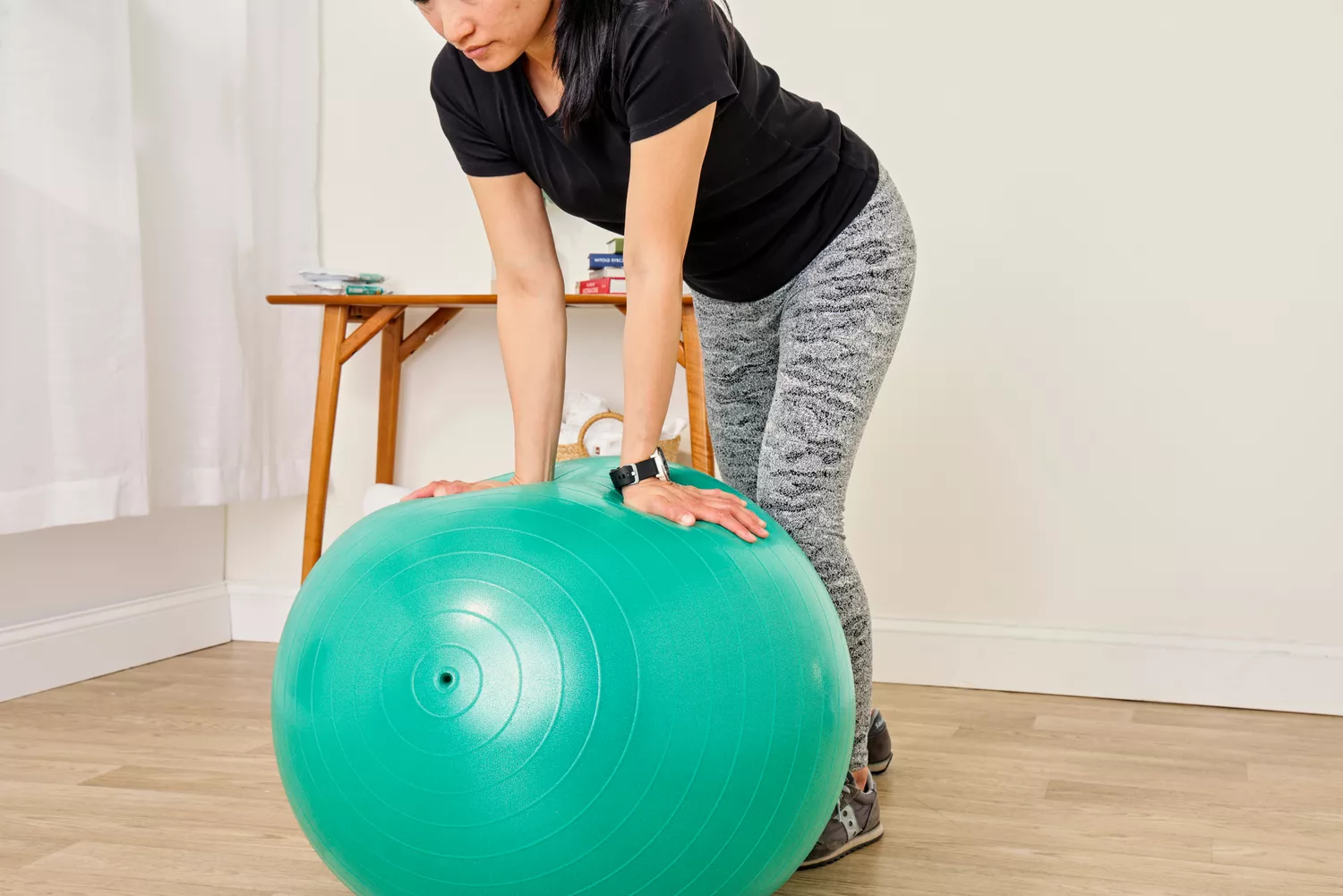 A person presses on the Gaiam Total Body Balance Ball Kit