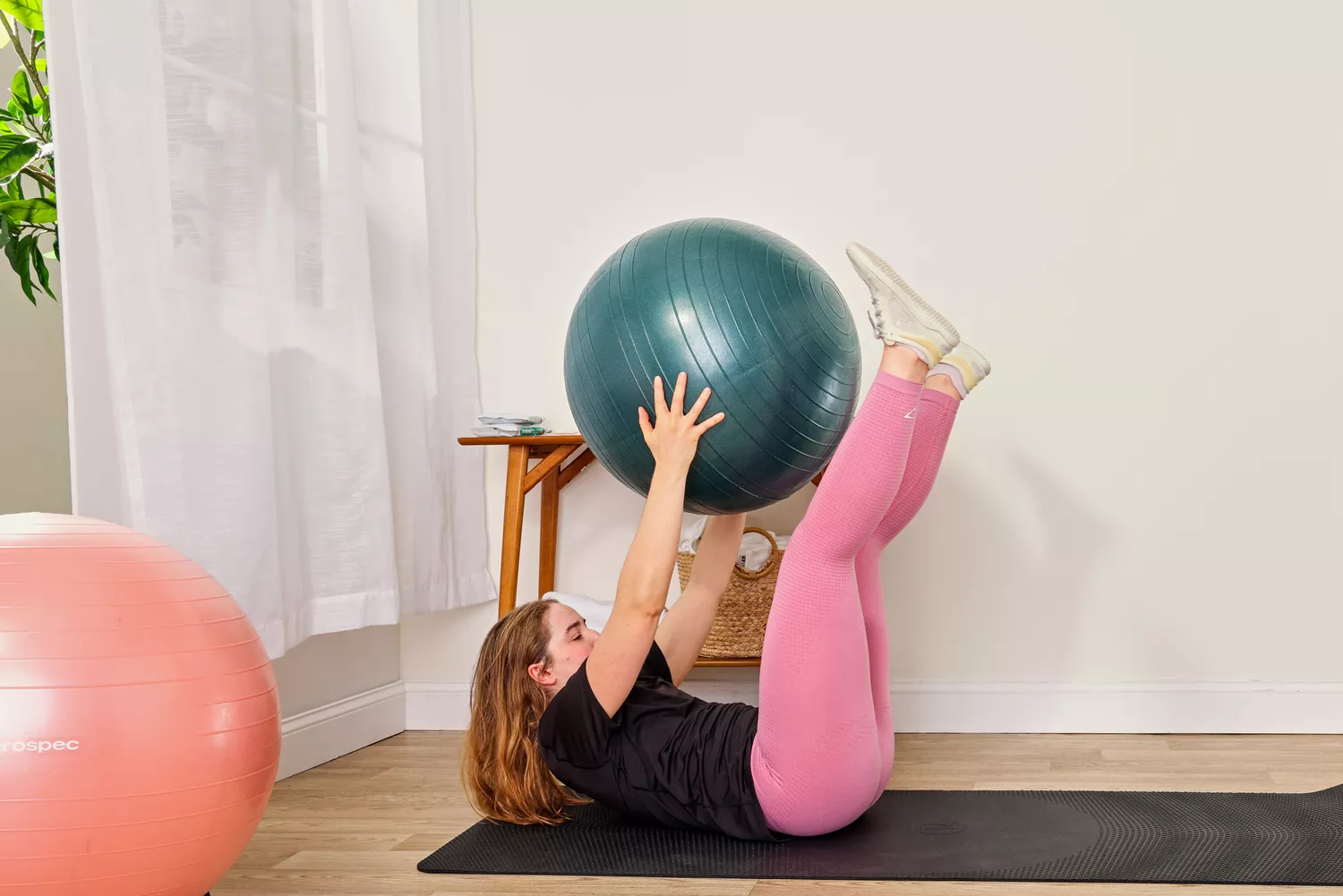 A person exercises using the Power Systems Versa Ball Pro Stability Ball