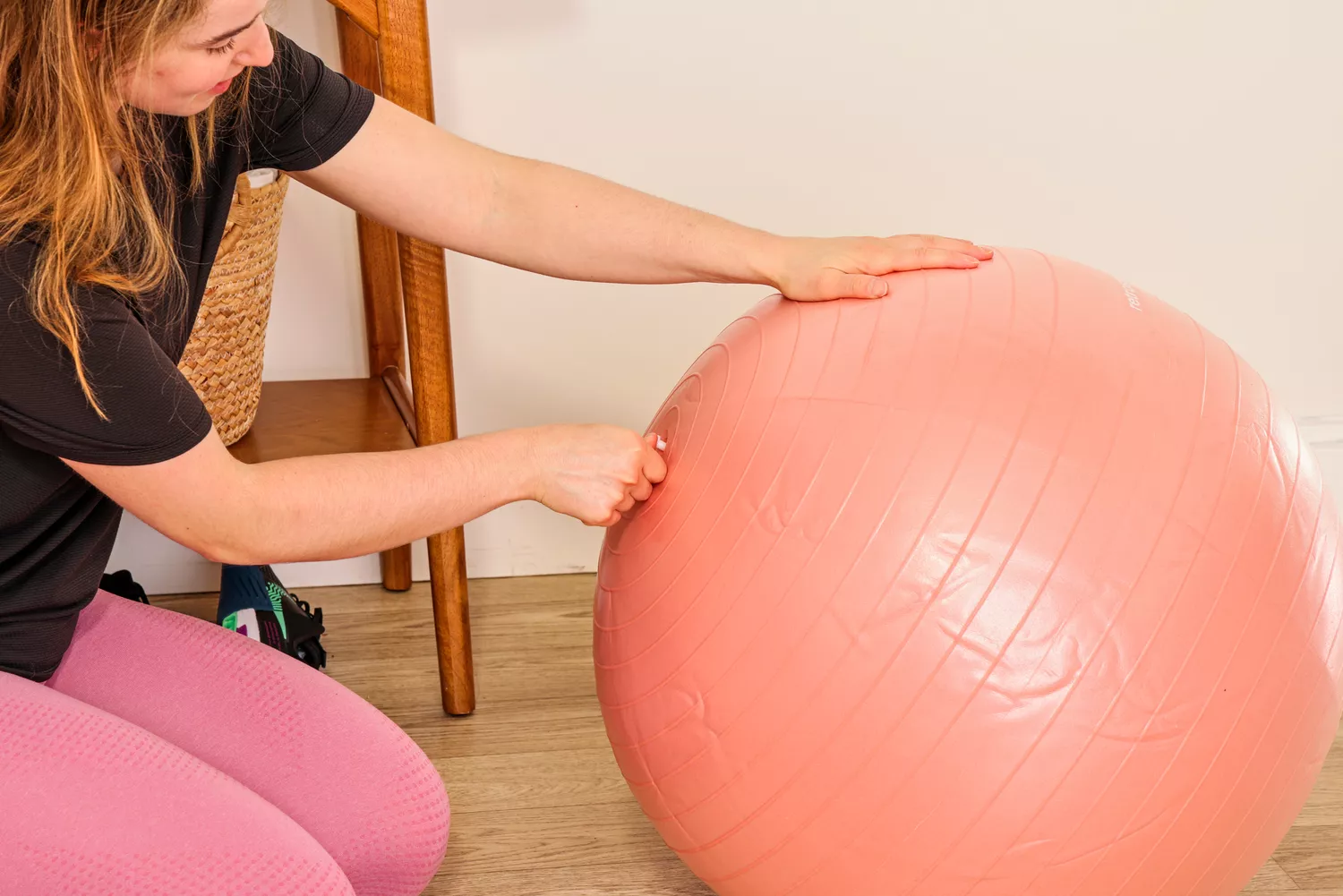 A person removes the plug on the Retrospec Luna Exercise Ball