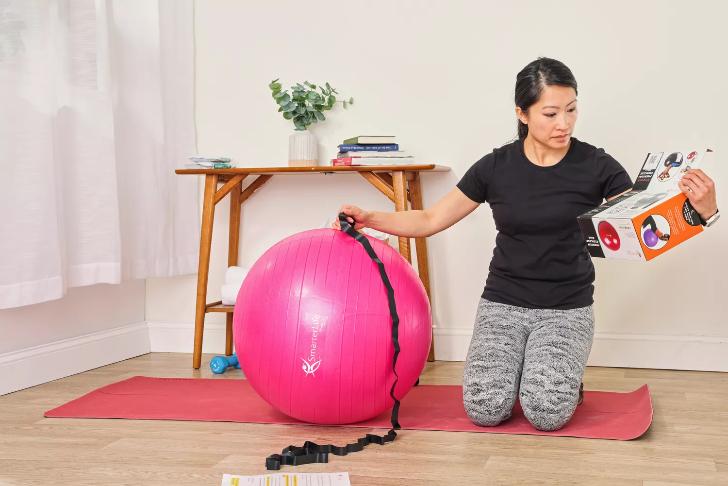 A person reads the instructions on the SmarterLife Workout Exercise Ball box