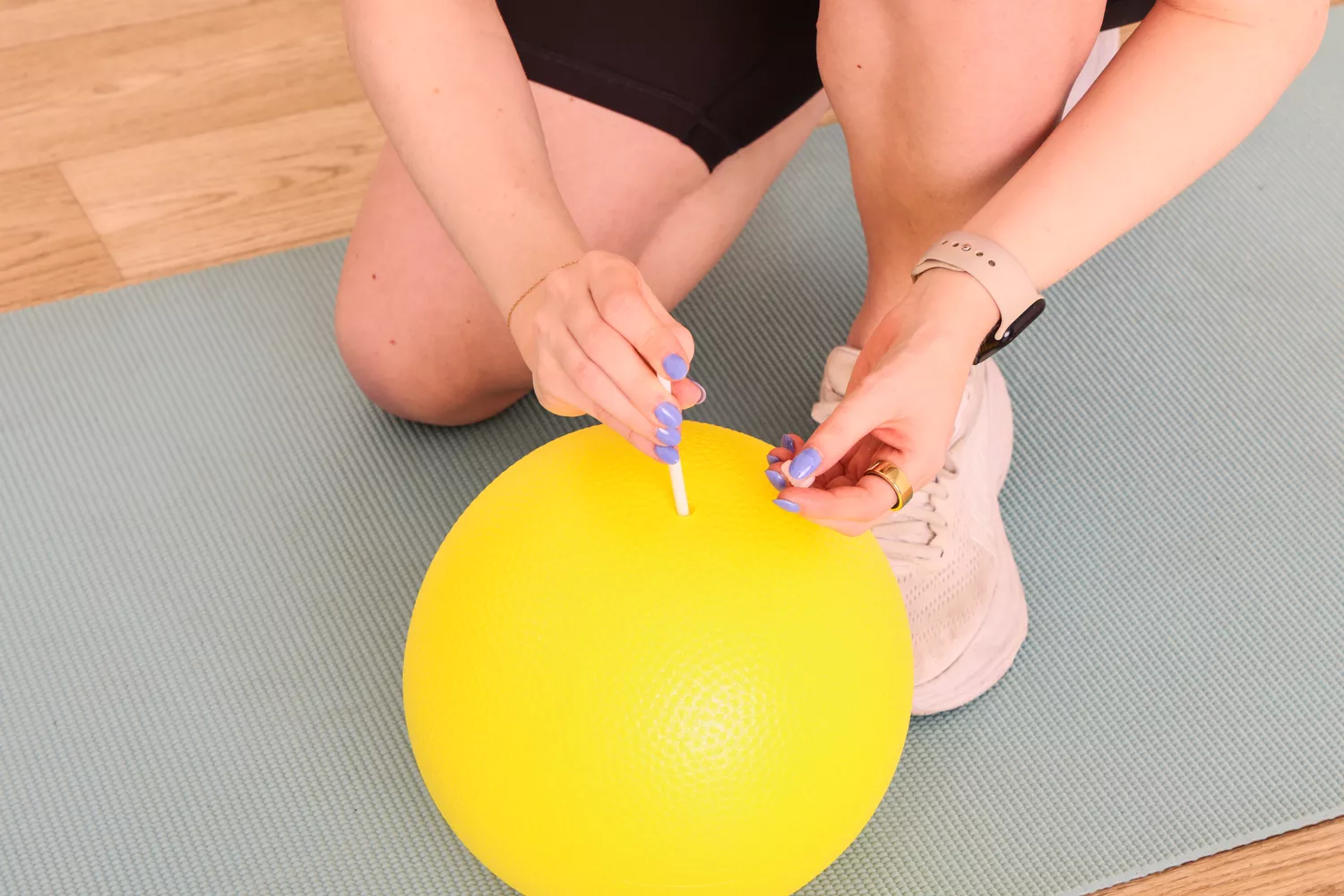A person plugs the Theraband Mini Exercise Ball