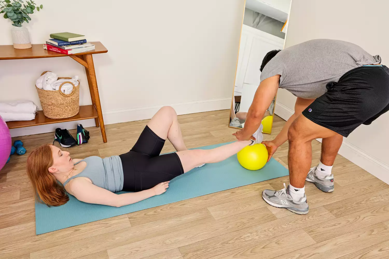 A person exercises using the Theraband Mini Exercise Ball