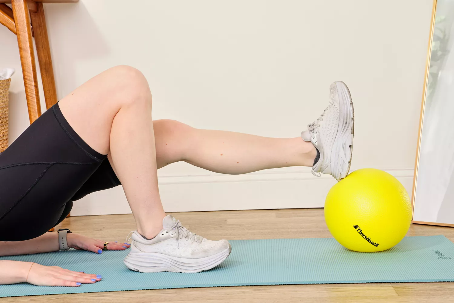 A person exercises using the Theraband Mini Exercise Ball