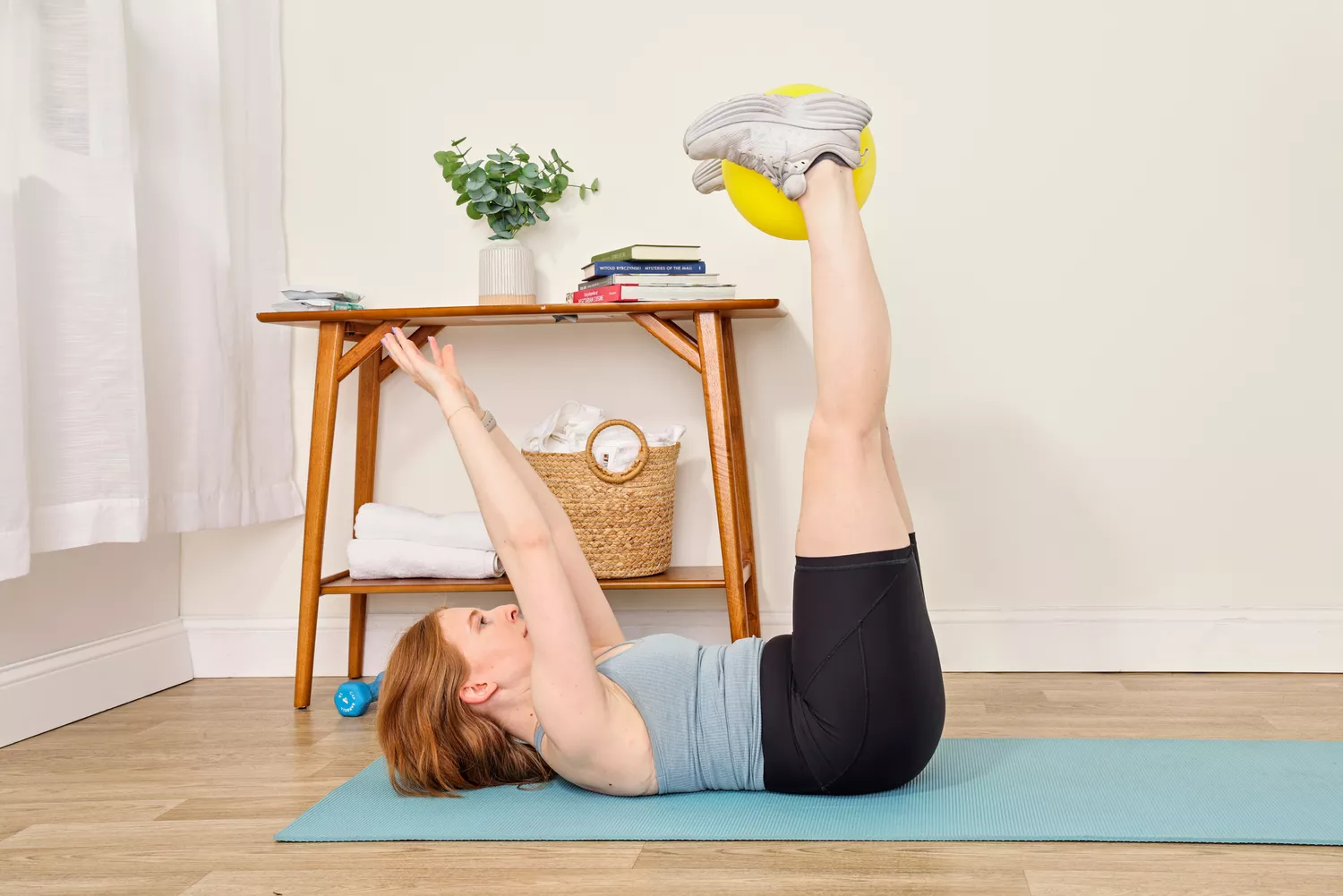 A person exercises using the Theraband Mini Exercise Ball