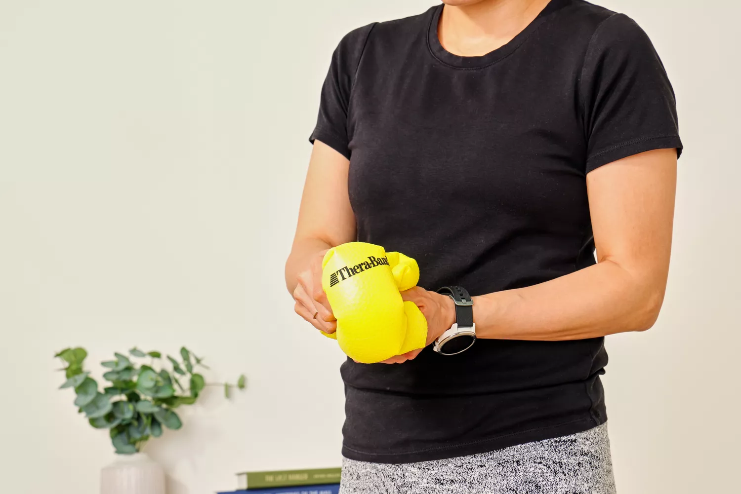 A person deflates the Theraband Mini Exercise Ball