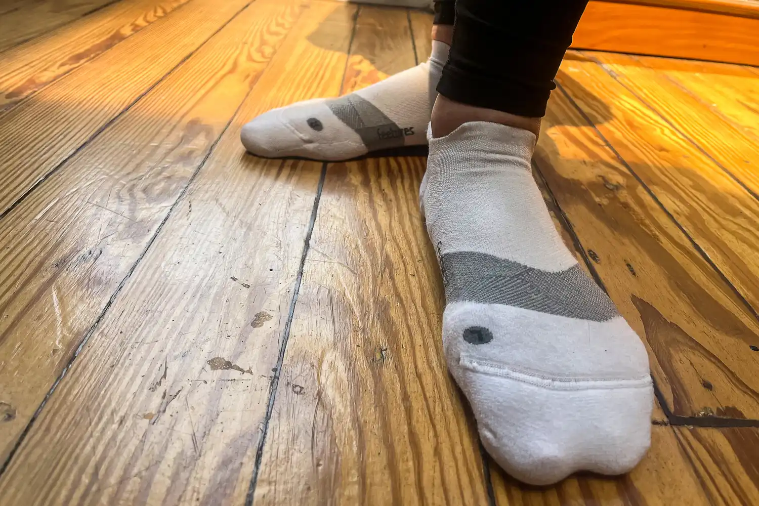 A person wears the Feetures Merino 10 Max Cushion Tab Socks