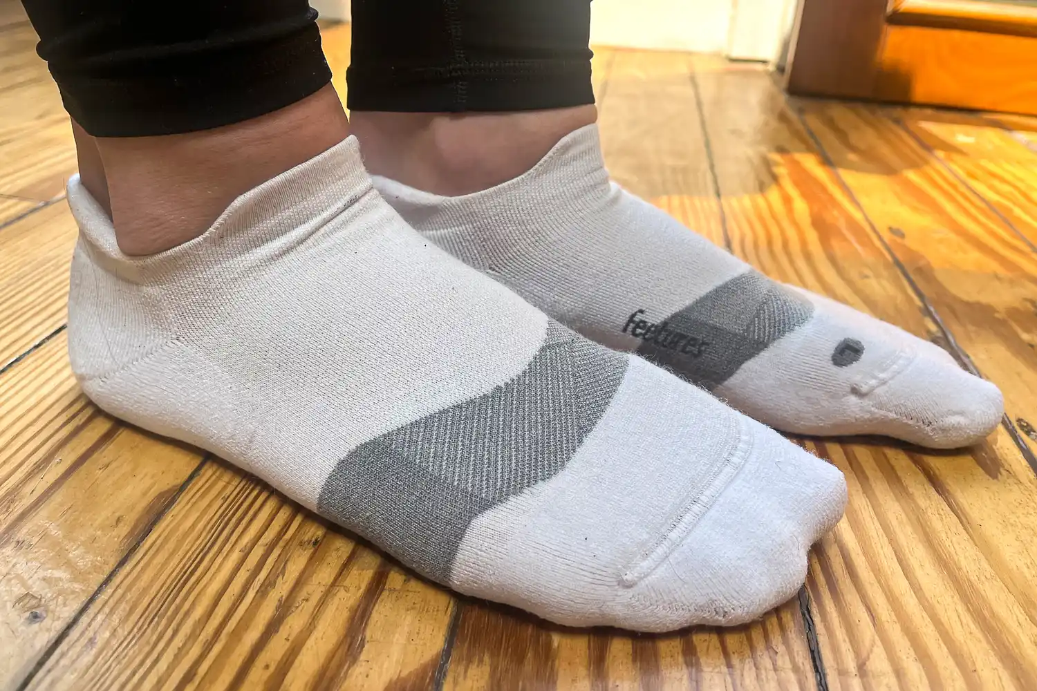 A side view of a person wearing the Feetures Merino 10 Max Cushion Tab Socks