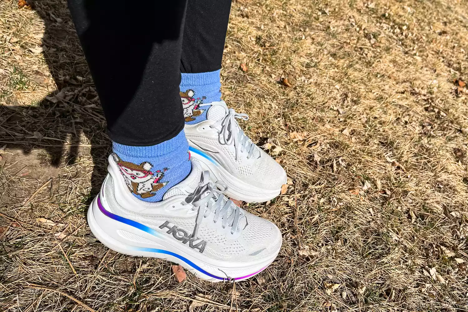 A person wears the Hoka Women's Bondi 9 outside in grass