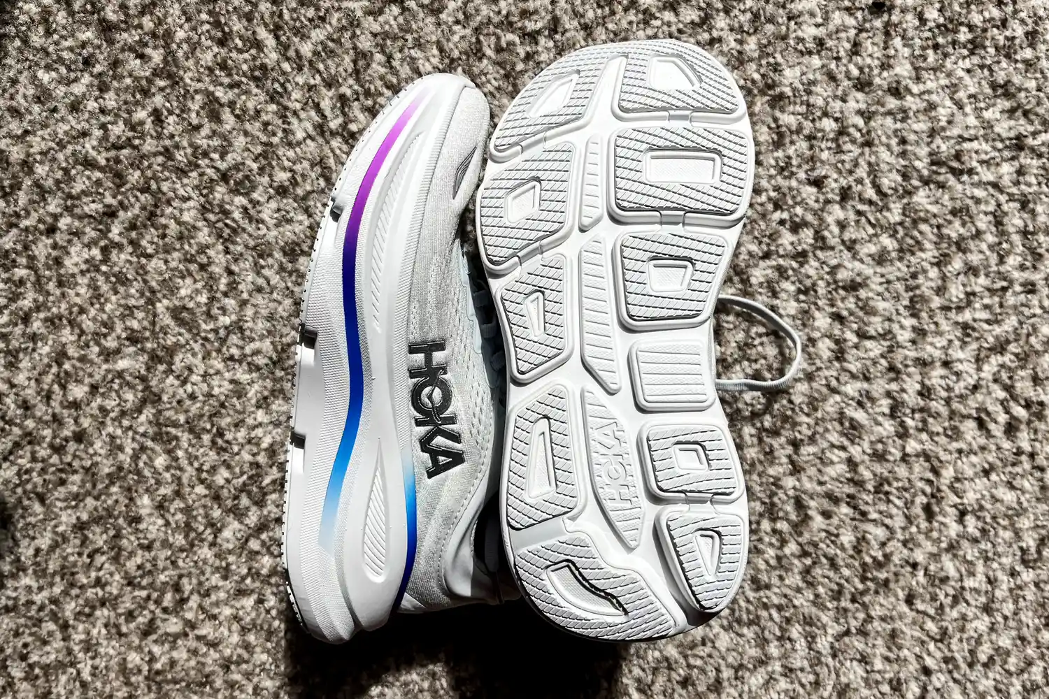 The Hoka Women's Bondi 9 sneakers posed n a carpet