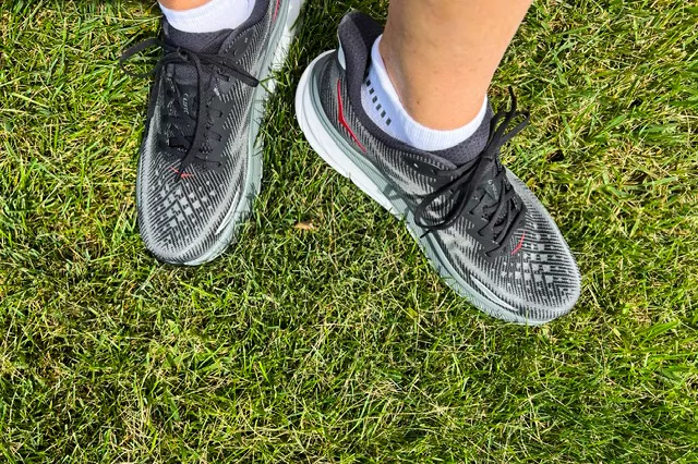 An overhead view of a person wearing the Hoka Men's Clifton 9 Running Shoe in grass