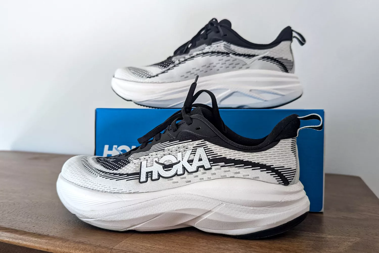 The Hoka Women's Skyflow sneakers posed around a box