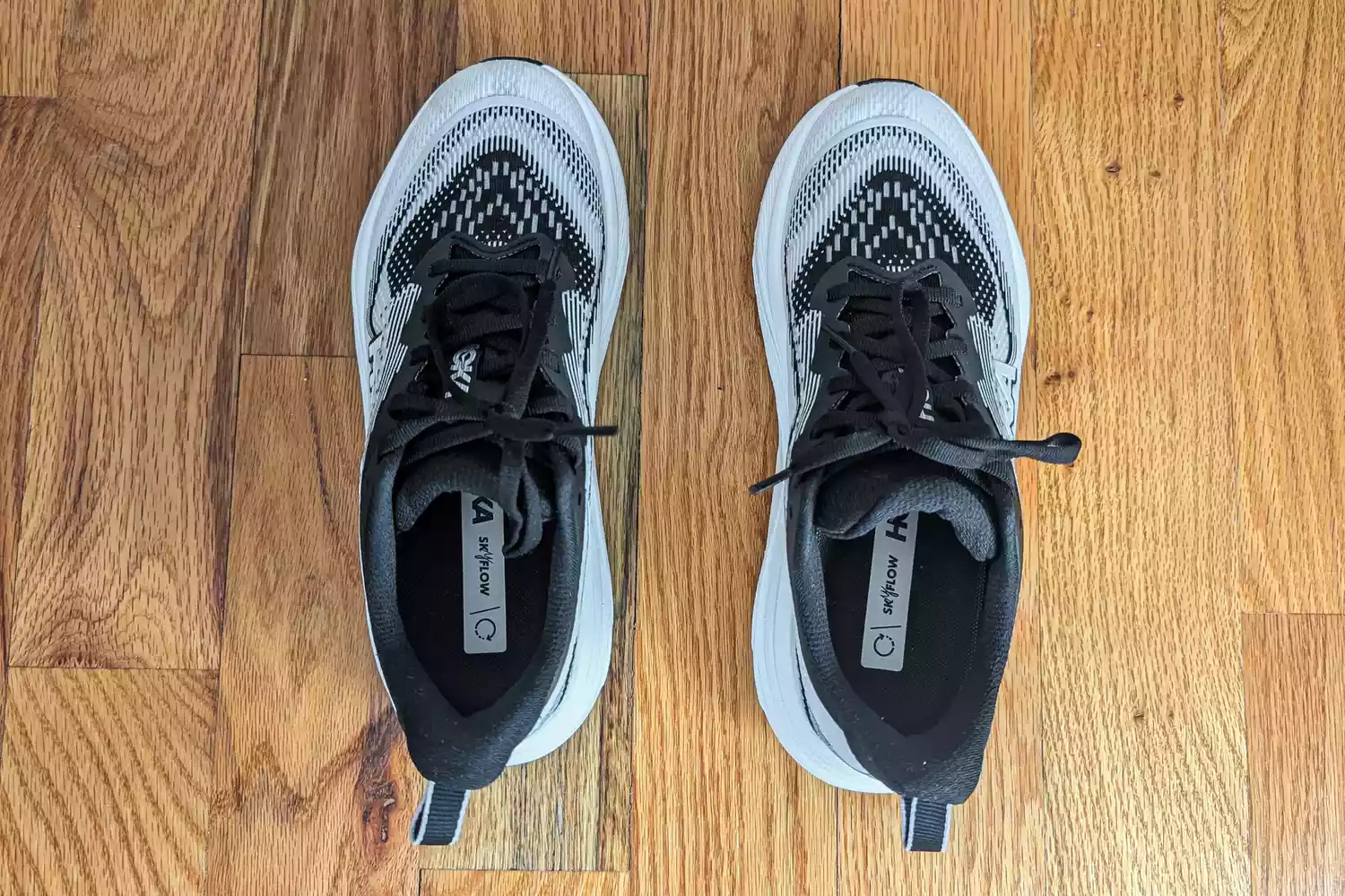 An overhead view of the Hoka Women's Skyflows on a wooden floor