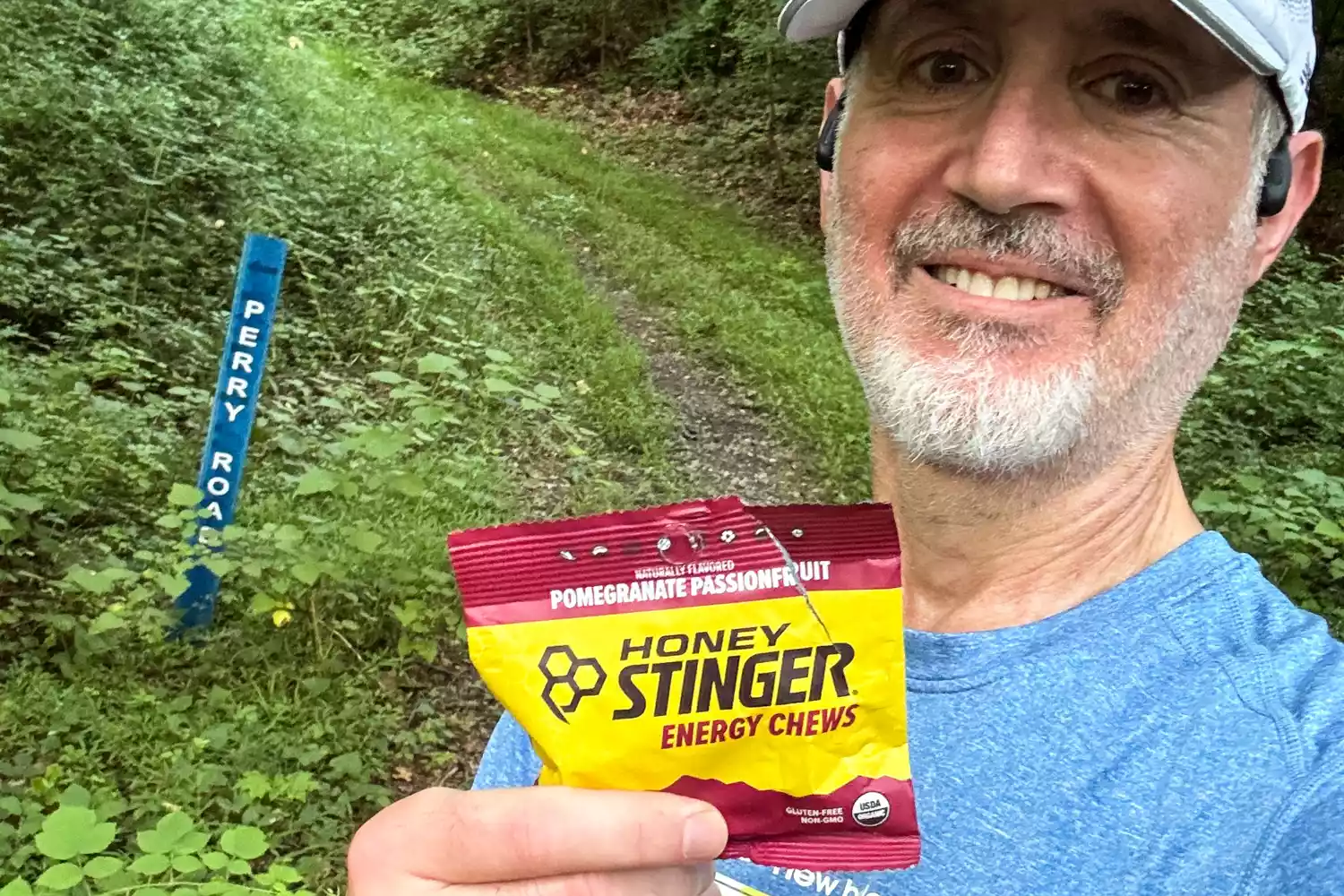 A person holds up a packet of Honey Stinger Organic Energy Chews