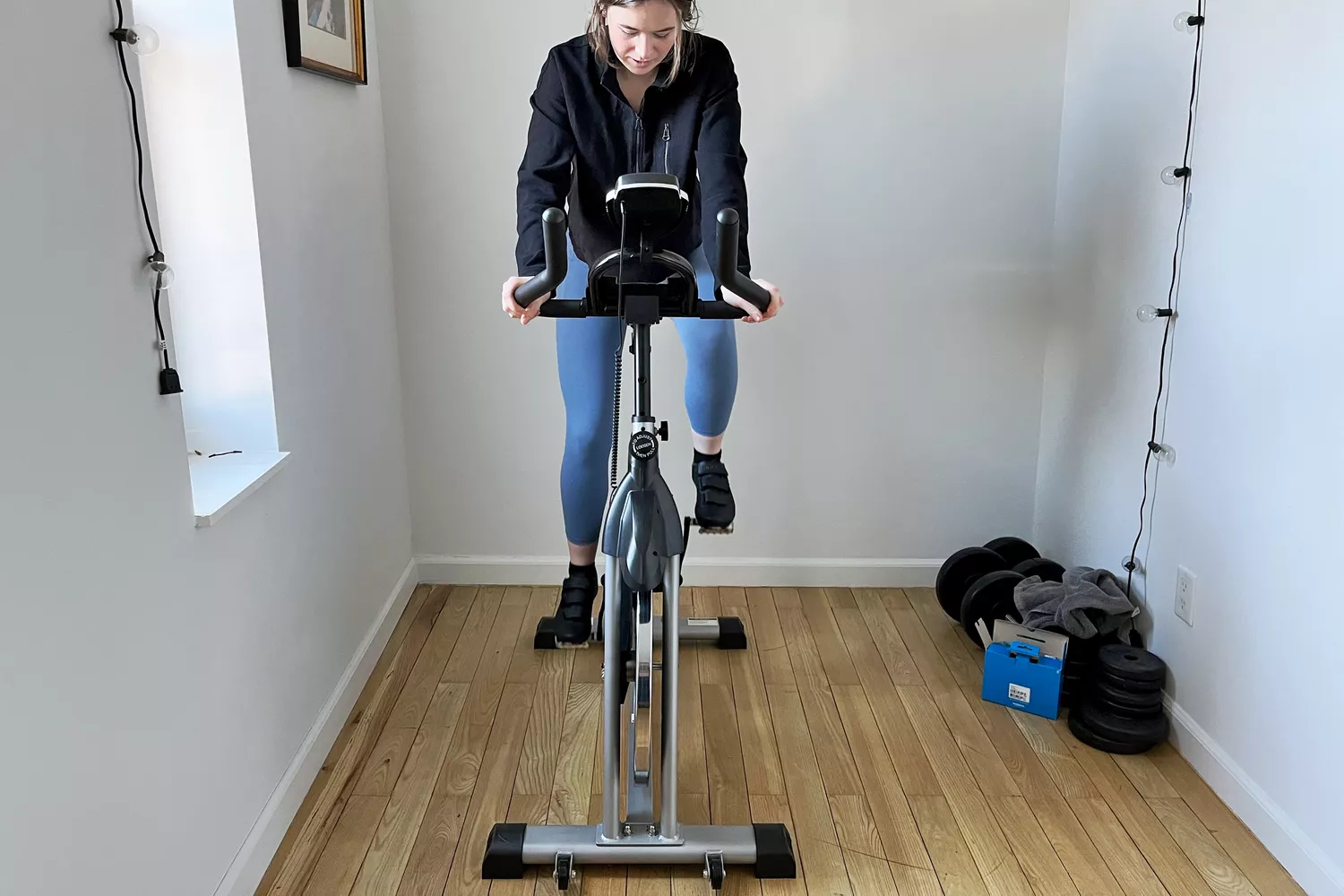 Person exercising on YOSUDA Indoor Cycling Bike in a narrow room