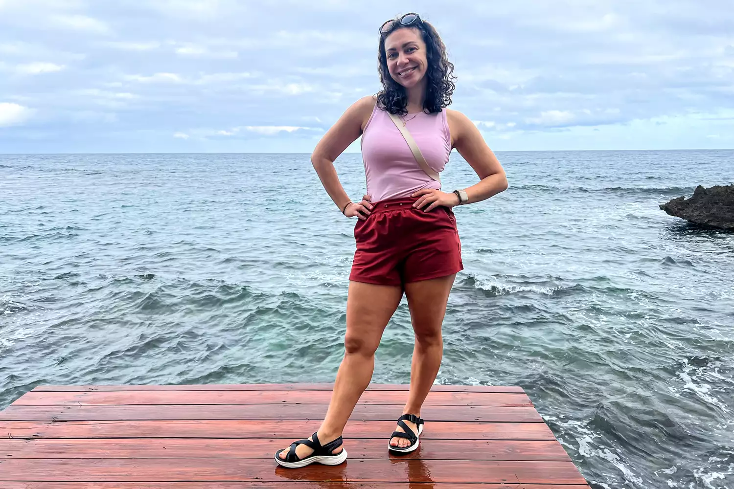 A person posing on a dock while wearing the Keen Women's Leiki Open-Toe Sandal