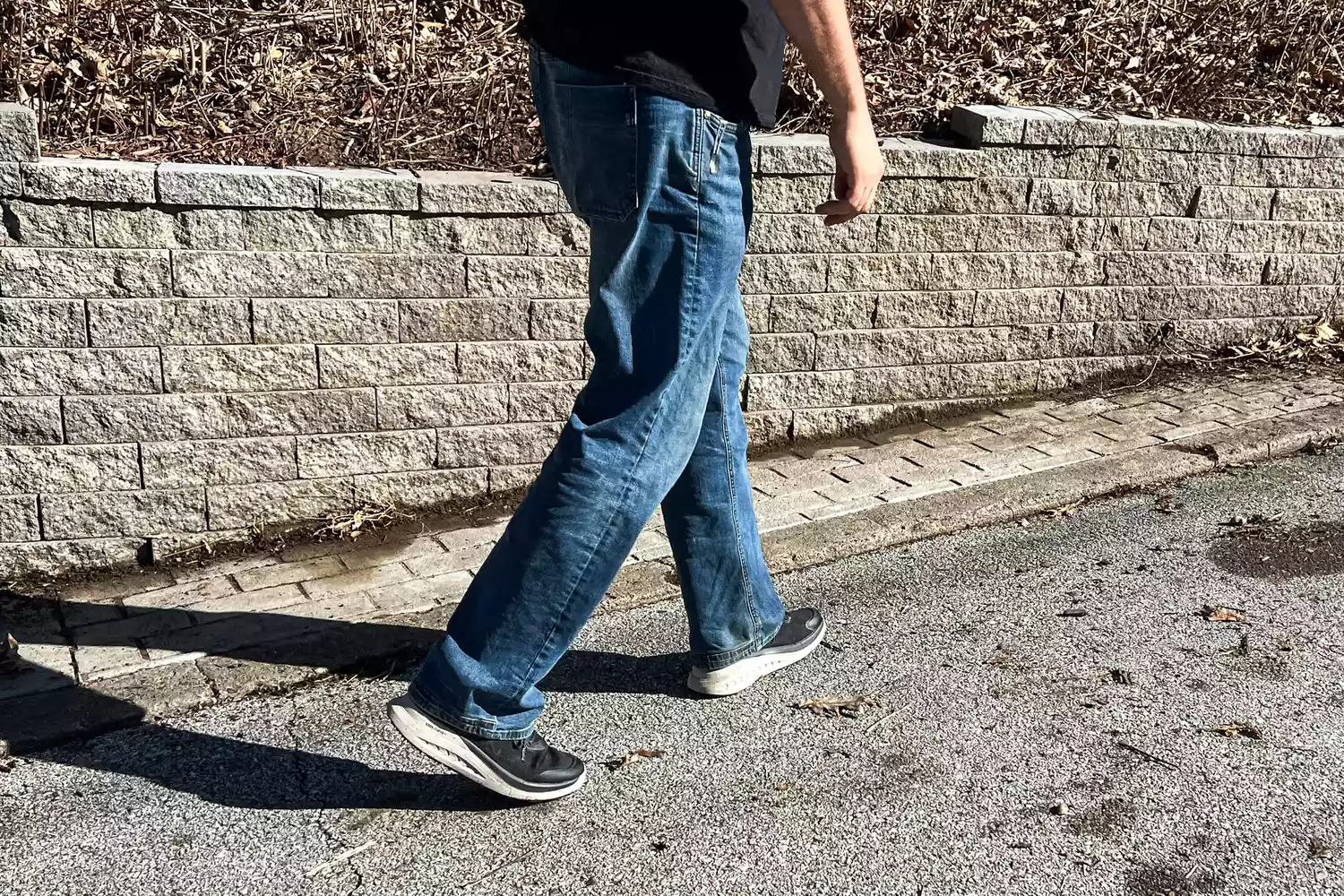 A close-up of legs walking on a road in the Keen Men's WK400 II Walking Shoe