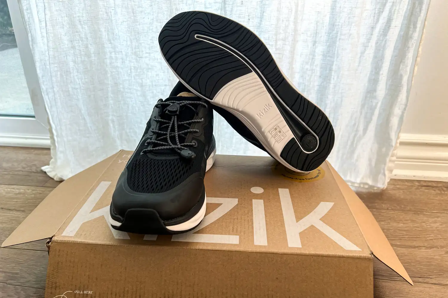 The Kizik Men's London sneakers posed on the box