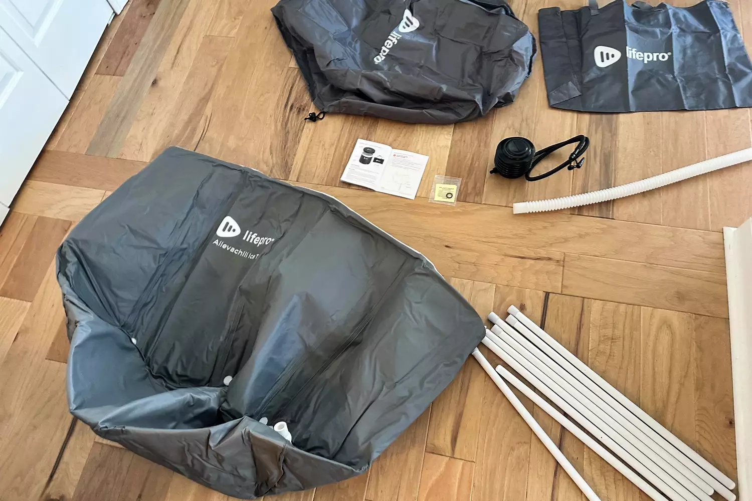 The Lifepro Allevachill Recovery Ice Tub's parts on a wood floor