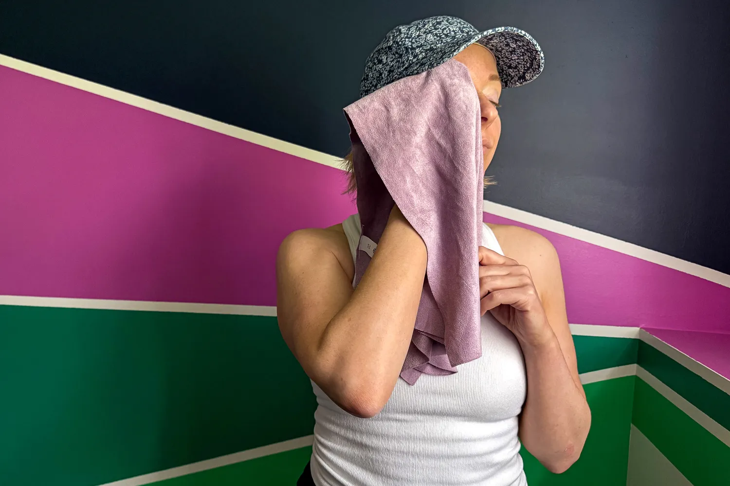 A person wipes their face with the lululemon The (Small) Towel