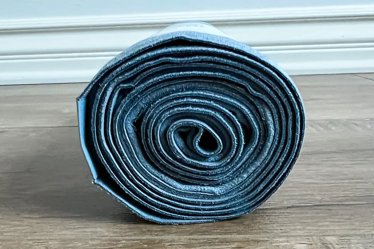 The lululemon The Towel rolled up on a wooden floor