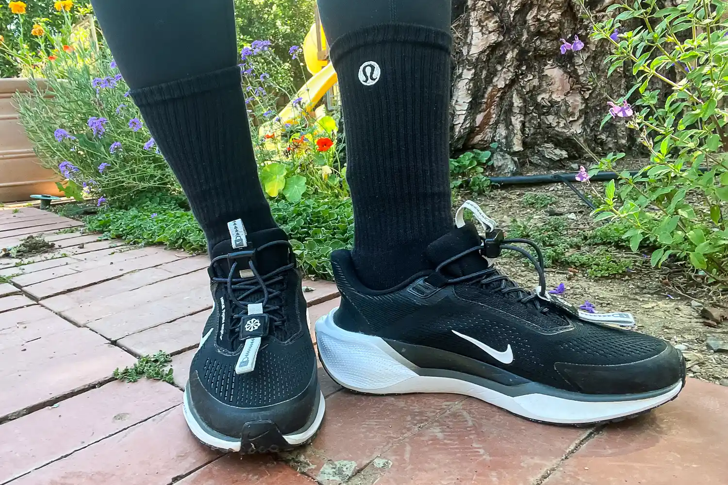 A person wears the lululemon Unisex Daily Essential Crew Socks while walking outside