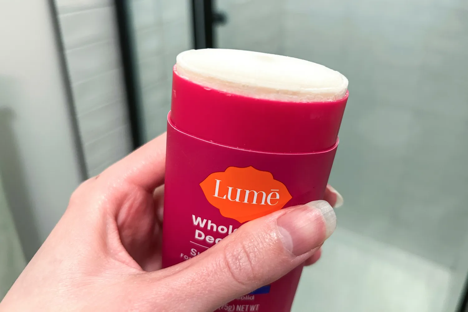 A person holds up the Lume Solid Stick Deodorant Plus Sweat Control