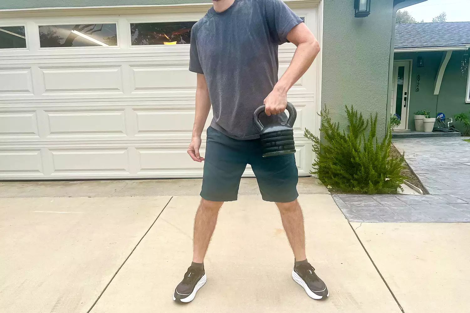 A person holds the Apex APKB-5009 Adjustable Heavy-Duty Kettlebell