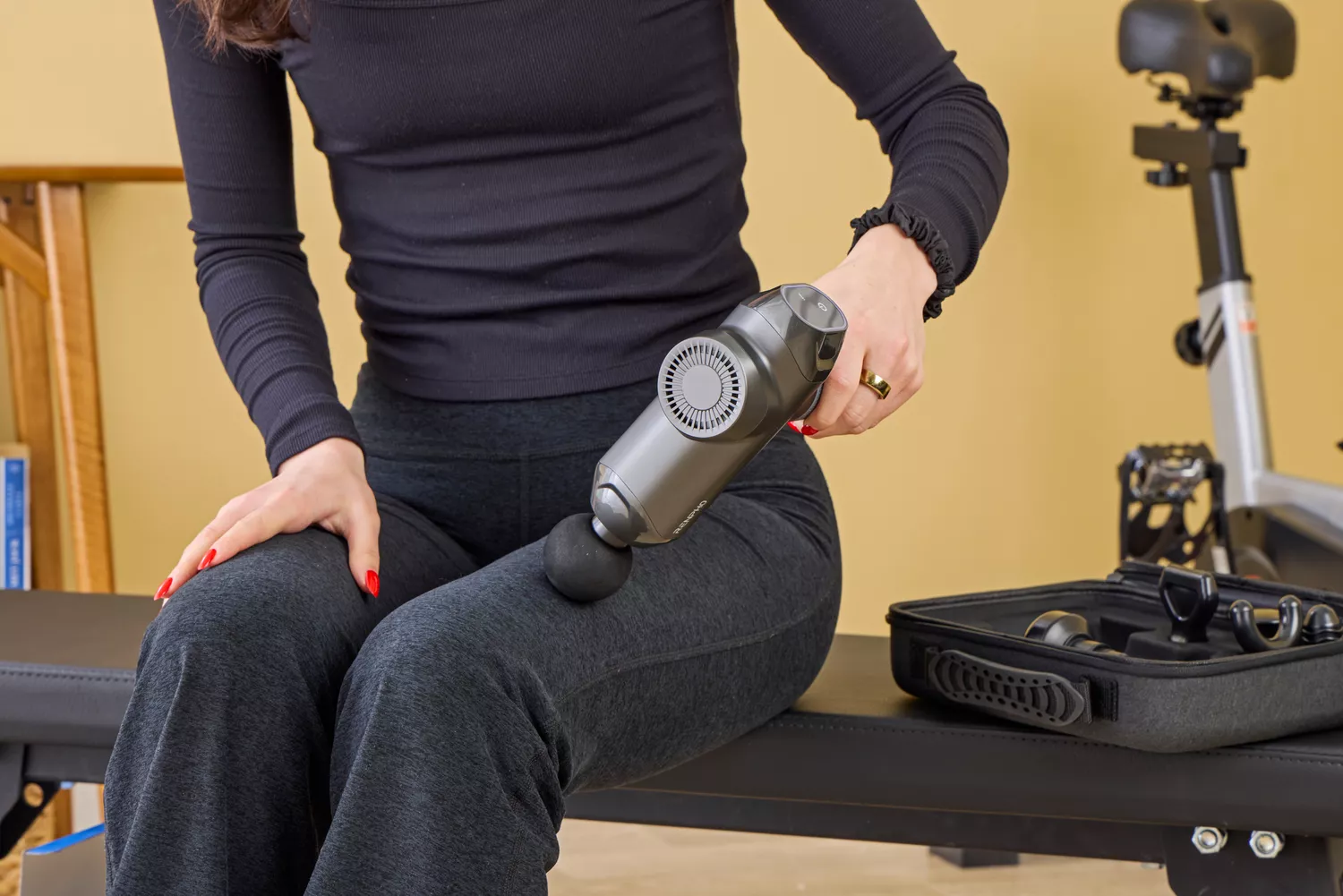 A person using the RENPHO Power Massage Gun on their leg