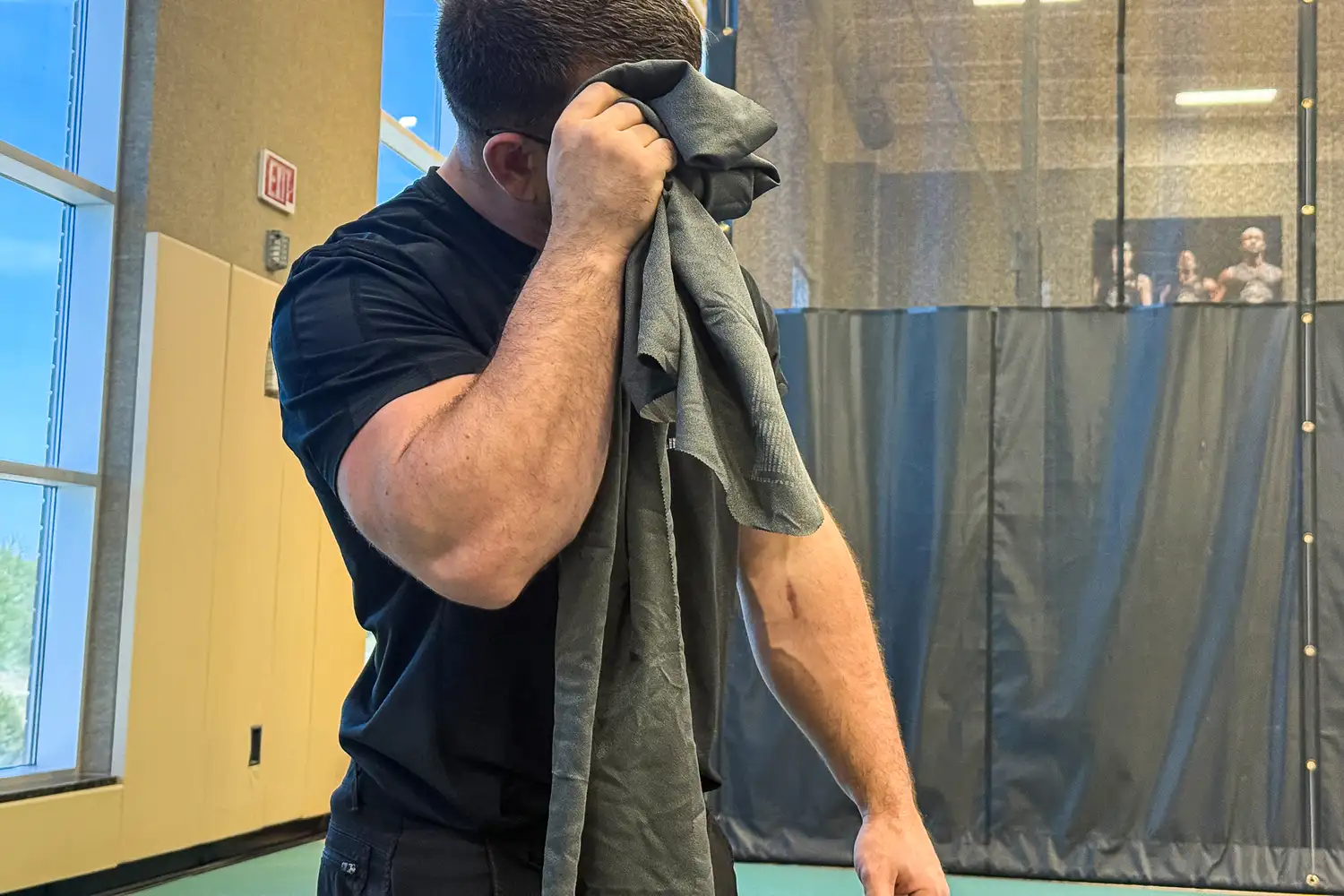 A person wipes their brow with the Matador Nanodry Towel