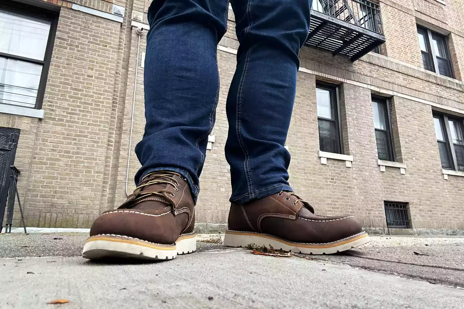 A person stands while wearing the Carhartt Menâs 6in Waterproof Wedge Soft Toe Work Boot