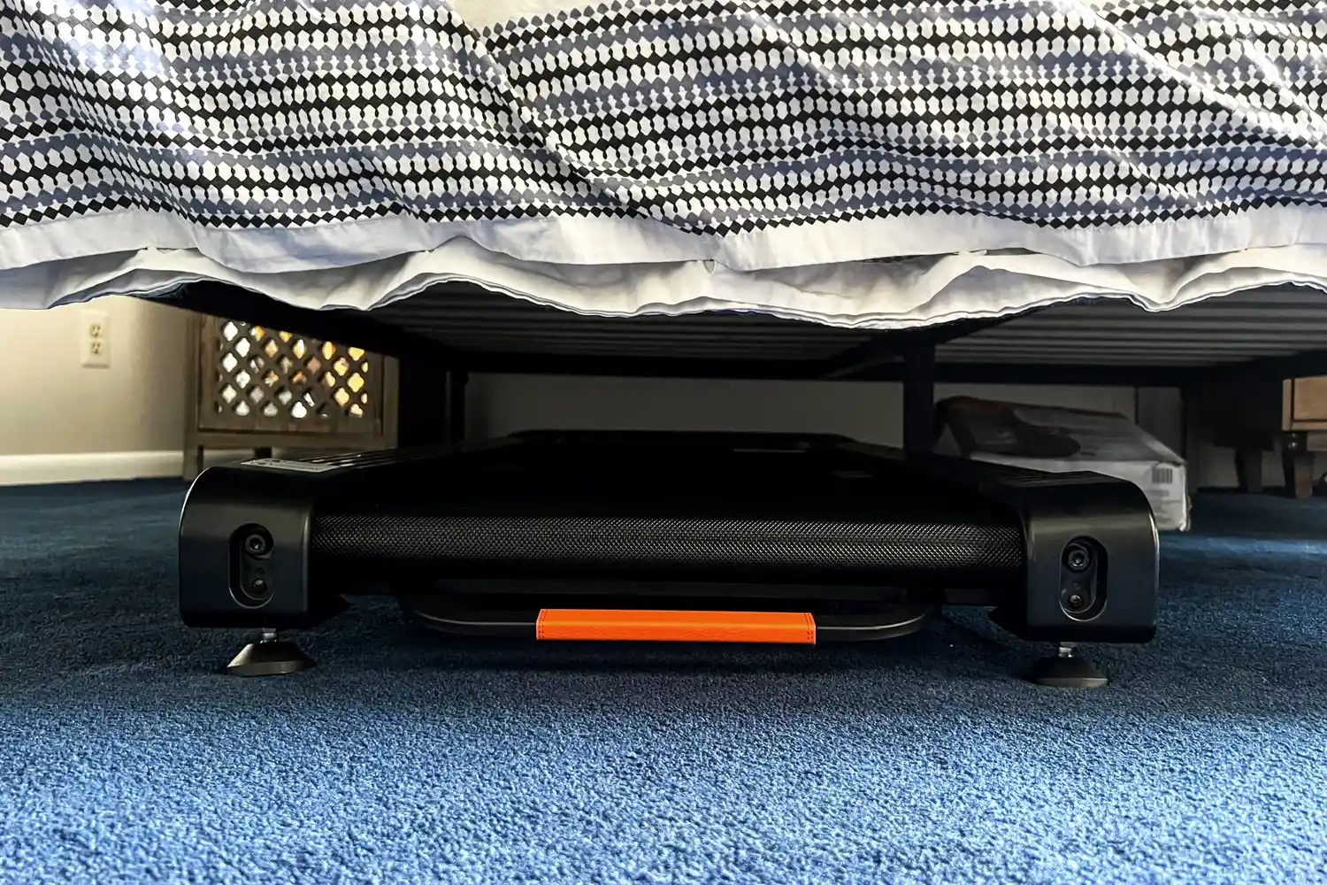 The Merach NovaWalk W50 TrekPad with Incline stored under a bed