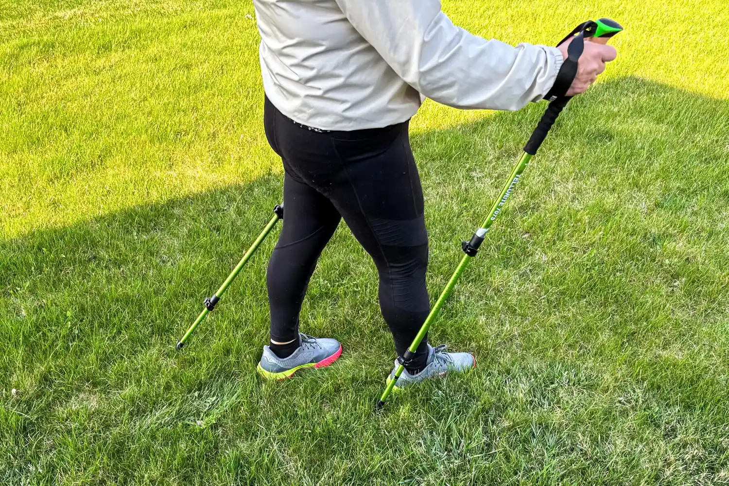 A side view of a person walking using the Mountainsmith Tellurite 7075 OLS Trekking Poles