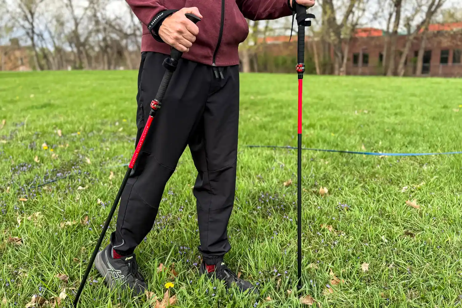A person walks through grass using the Mountain Safety Research DynaLock Ascent Carbon Backcountry Poles