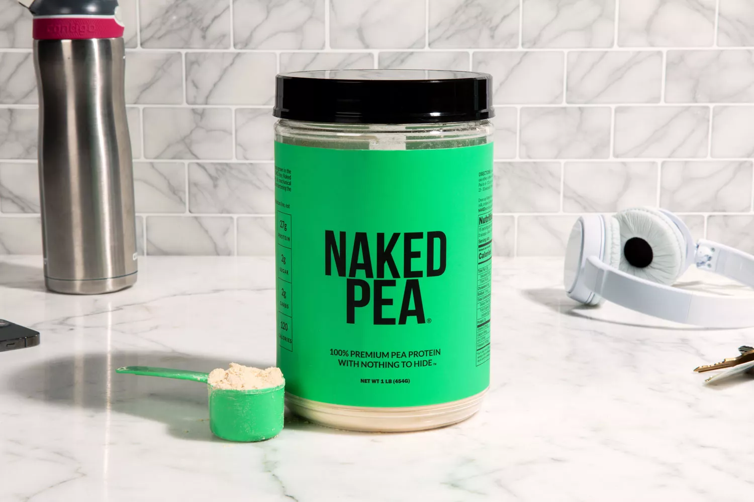 NAKED nutrition NAKED PEA 1LB Pea Protein Isolate on marble counter with scoop