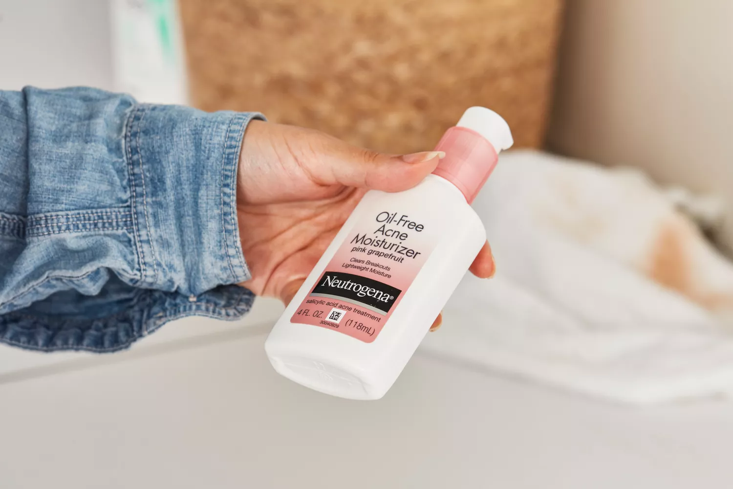Hand holding a bottle of Neutrogena Pink Grapefruit Oil-Free Acne Moisturizer