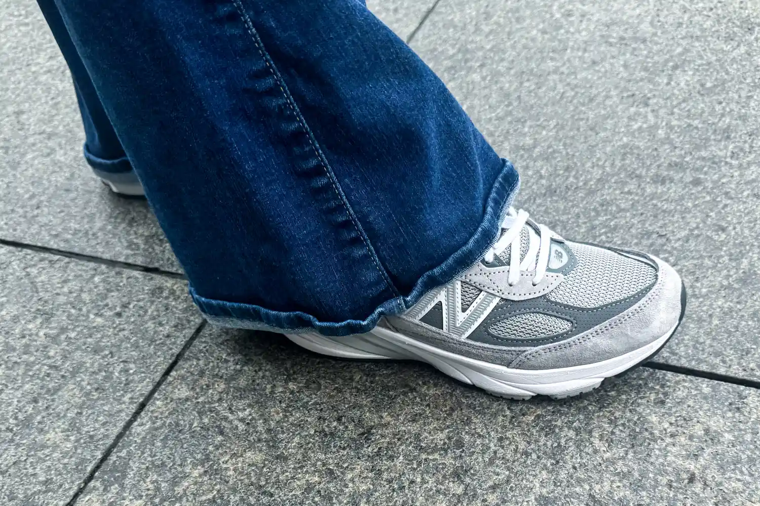 A person walks outside while wearing the New Balance Women's Made in USA 990v6 Sneakers