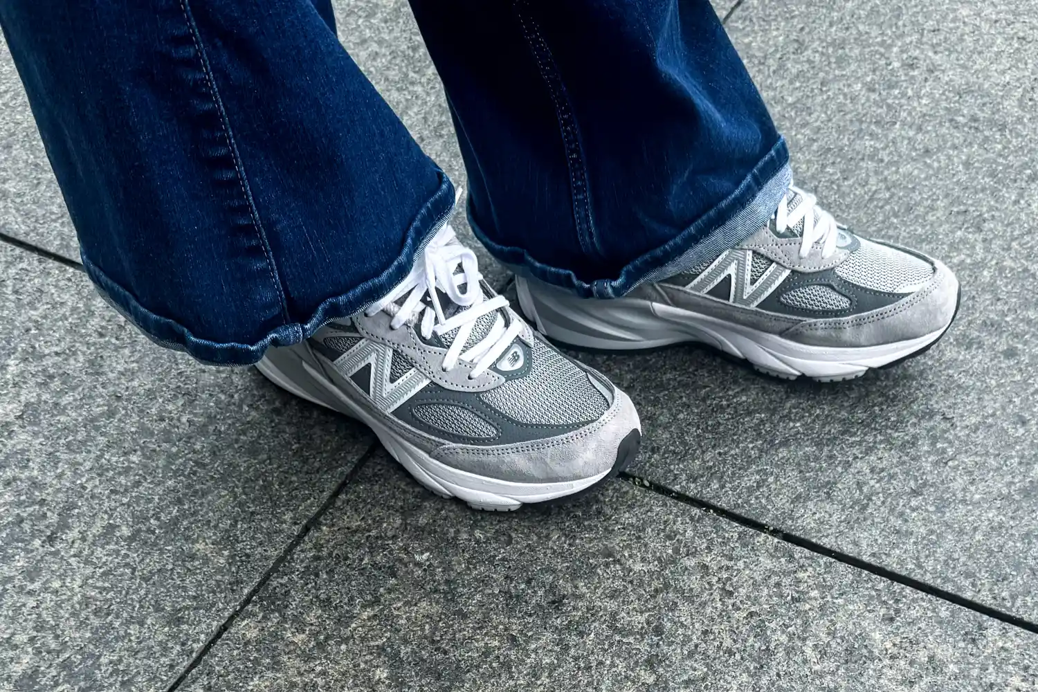 A person wears the New Balance Women's Made in USA 990v6 Sneakers with jeans