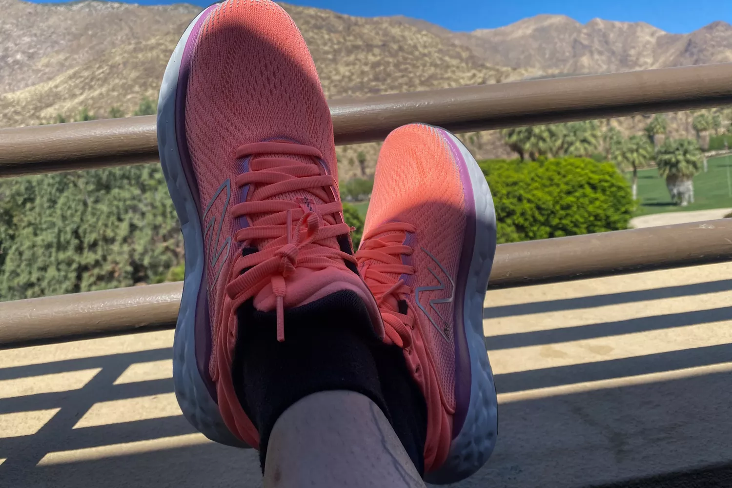 Two feet crossed while wearing New Balance Women's Fresh Foam X 840v1 in front of a mountainous landscape